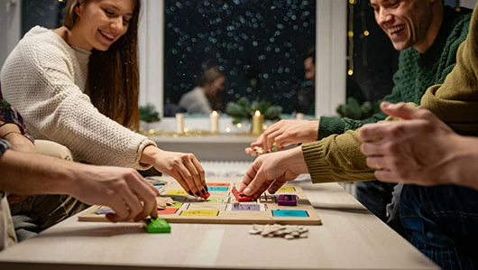 Компания друзей увлеченно играют в настольную игру